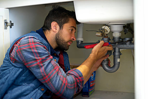 Plumber working under a sink.